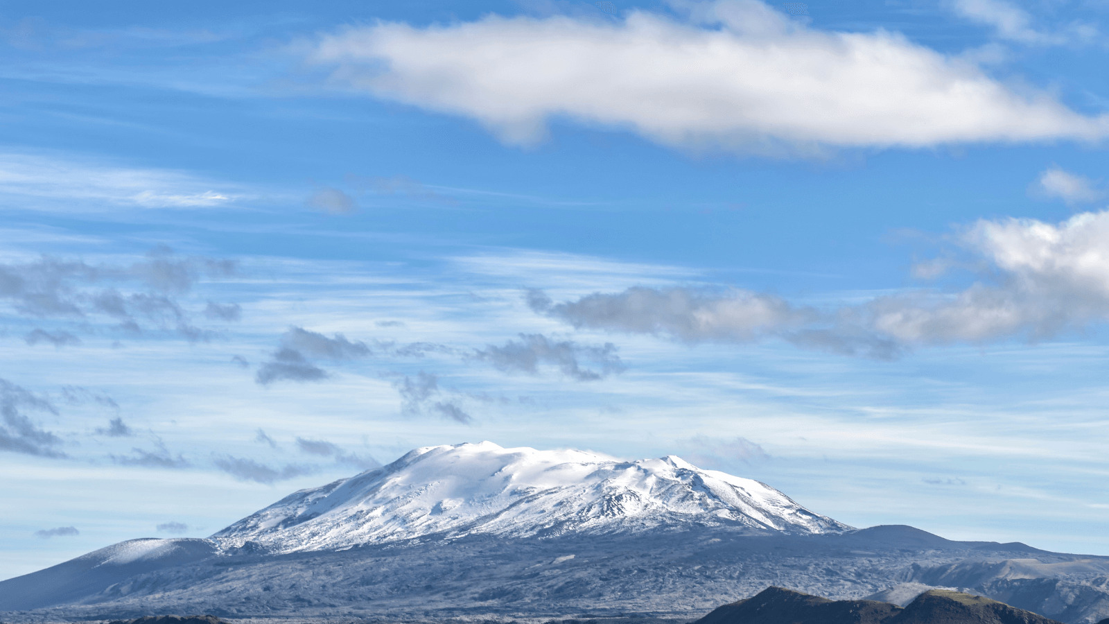 Snow-covered Hekla volcano on a summer day.